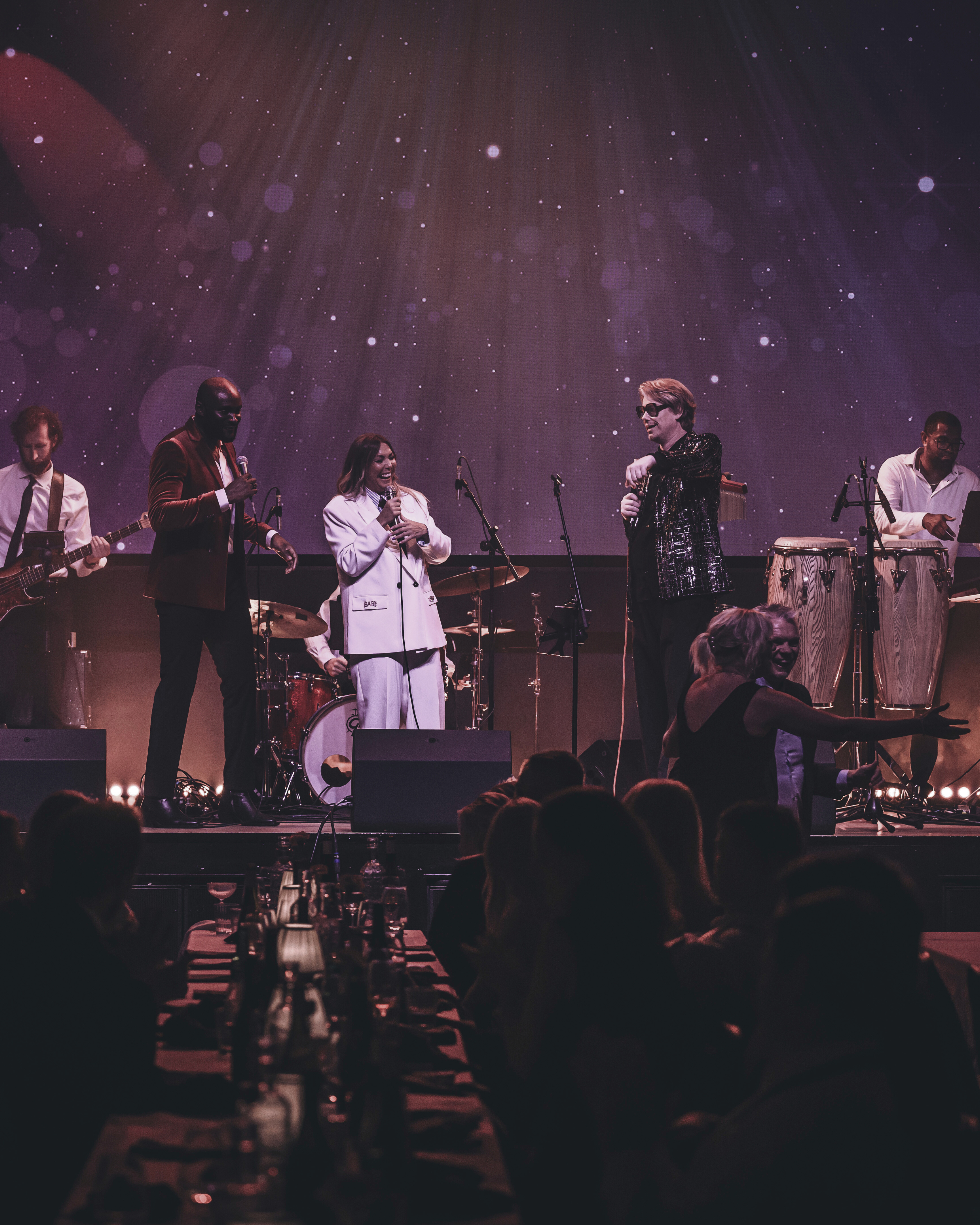 The band singing and dancing on the stage