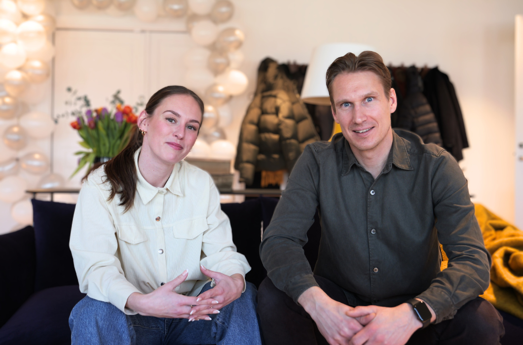 Two people in sofa looking into the camera